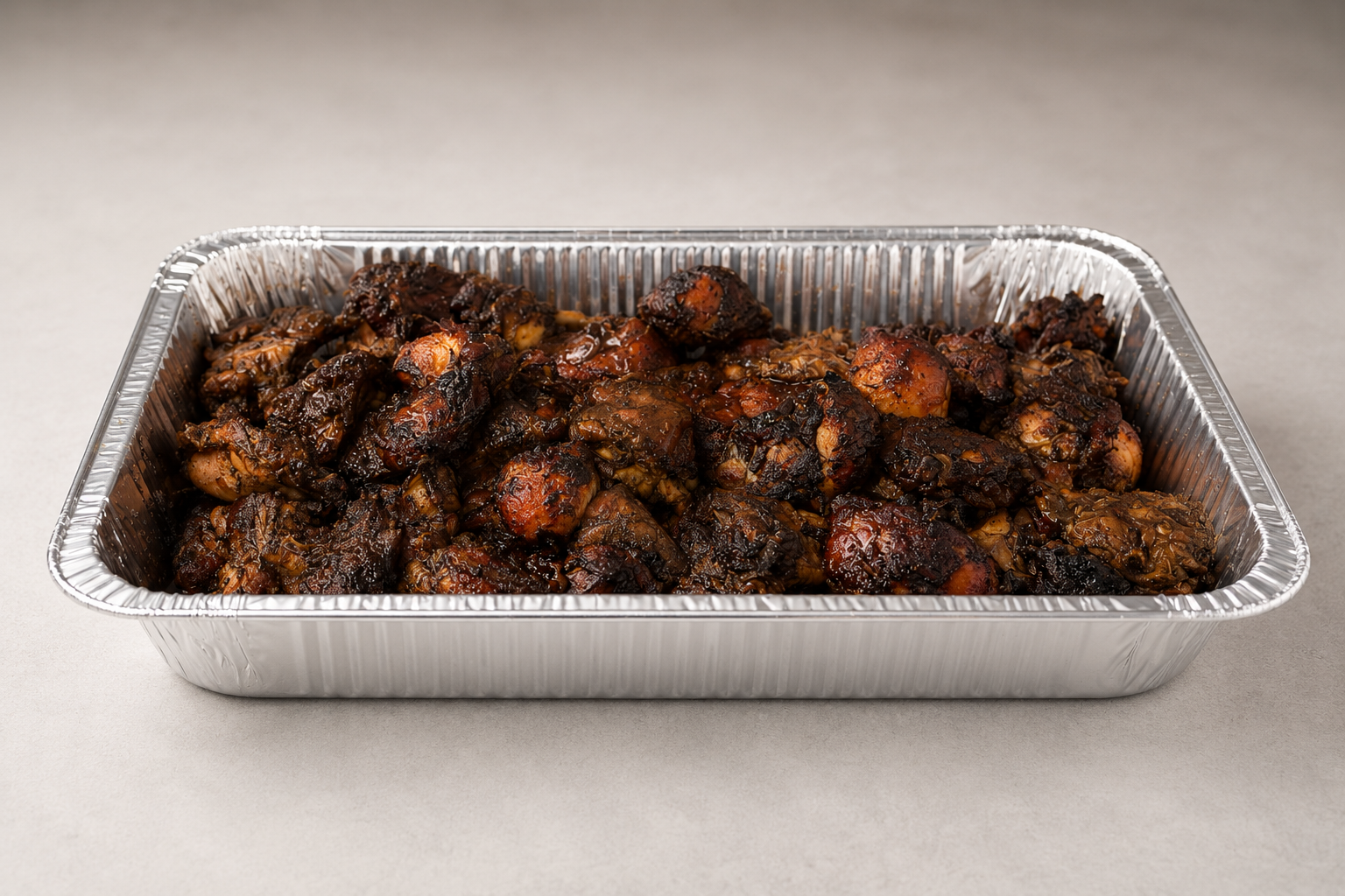 Large catering tray filled with Jamaican jerk chicken